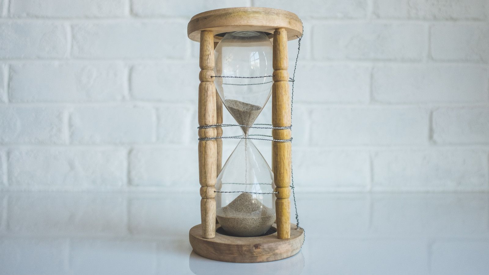 Sand flowing through an hourglass, representing the critical importance of precise time synchronization across distributed systems using Network Time Protocol (NTP)